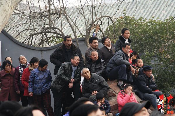 人民公園演出現(xiàn)場擠滿了觀眾，圖為觀眾爬上假山山頭