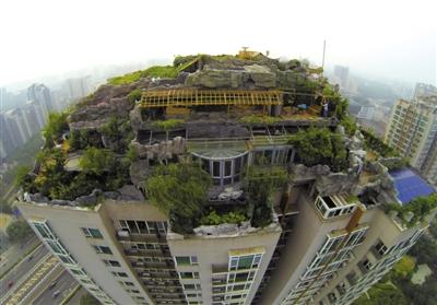 　　昨日，身穿橘黃色馬甲的工作人員在人濟山莊樓頂拆除違章建筑。新京報記者 吳江 攝