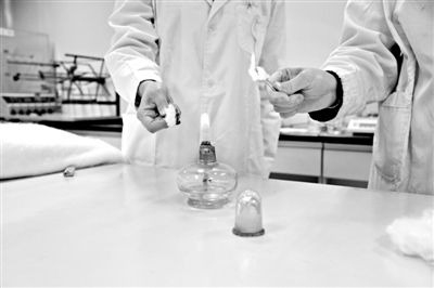實驗人員操作的燃燒檢測法中，真蠶絲離開火焰就熄滅(左)。
