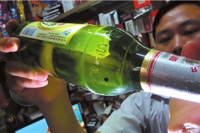 這瓶未開封的燕京啤酒內(nèi)有一顆黑色懸浮物。京華時報記者 徐曉帆 攝