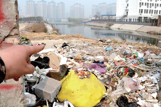 金水河長江路橋下河水發(fā)臭，水邊堆放眾多垃圾
