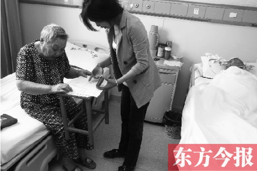 昨日，鄭大五附院二號(hào)樓住院部，馬老太寫下委托書，并簽字摁指印委托女兒代理為昏迷老伴解鎖取錢