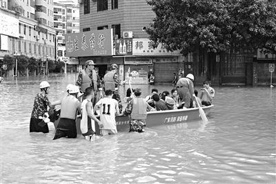 18日，廣東省清遠市陽山縣縣城,消防官兵合力推動沖鋒舟，轉(zhuǎn)移被困學生。新華社發(fā)