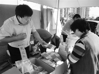昨日，河南企業(yè)家劉春喜在京“練攤”，為顧客挑選綠豆。新京報記者 張玉學(xué) 攝