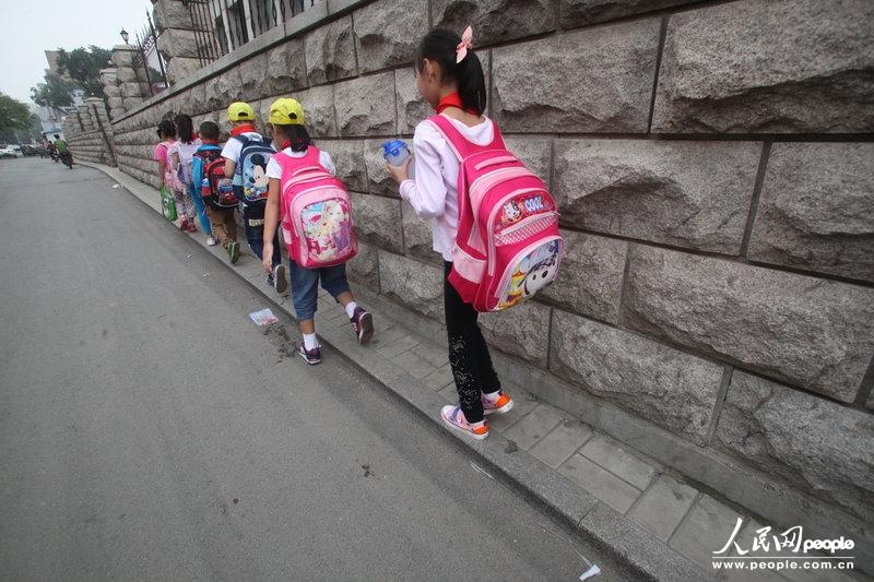 2013年09月11日，濟(jì)南運(yùn)署街上，小學(xué)生走史上“最窄人行道”上學(xué)。