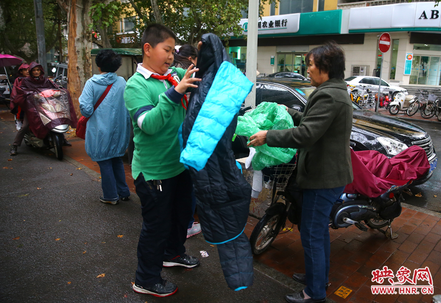 學(xué)校門口，家長給孩子帶來了御寒的厚衣服。