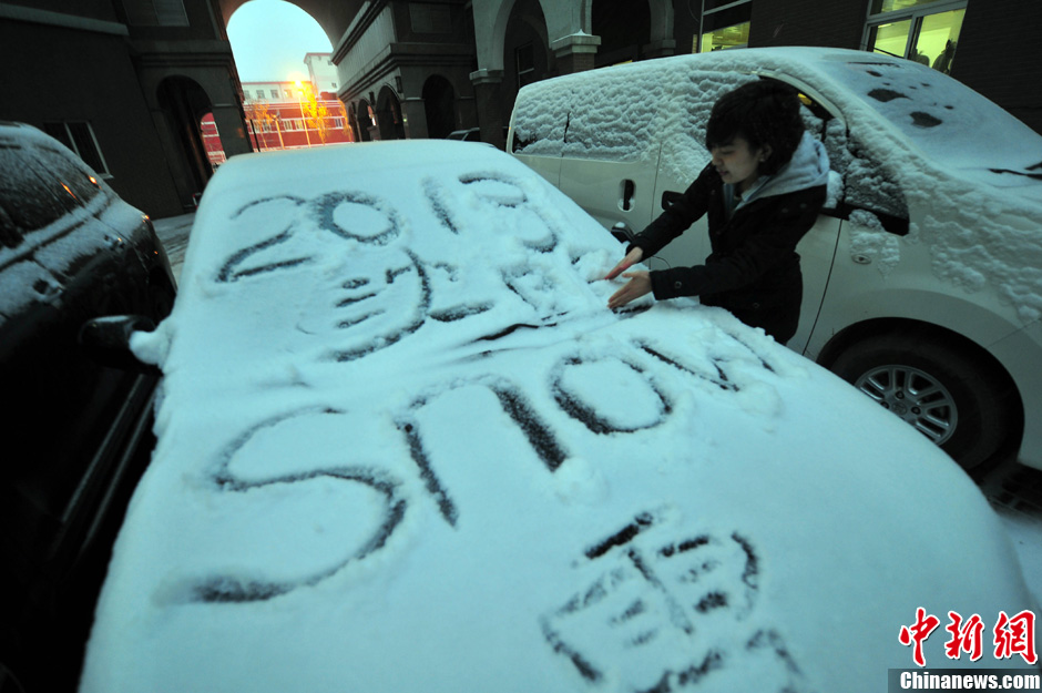 11月18日，行人在車輛的積雪上涂鴉。