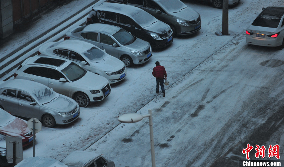 11月18日，行人在沈陽街頭的積雪中穿行。