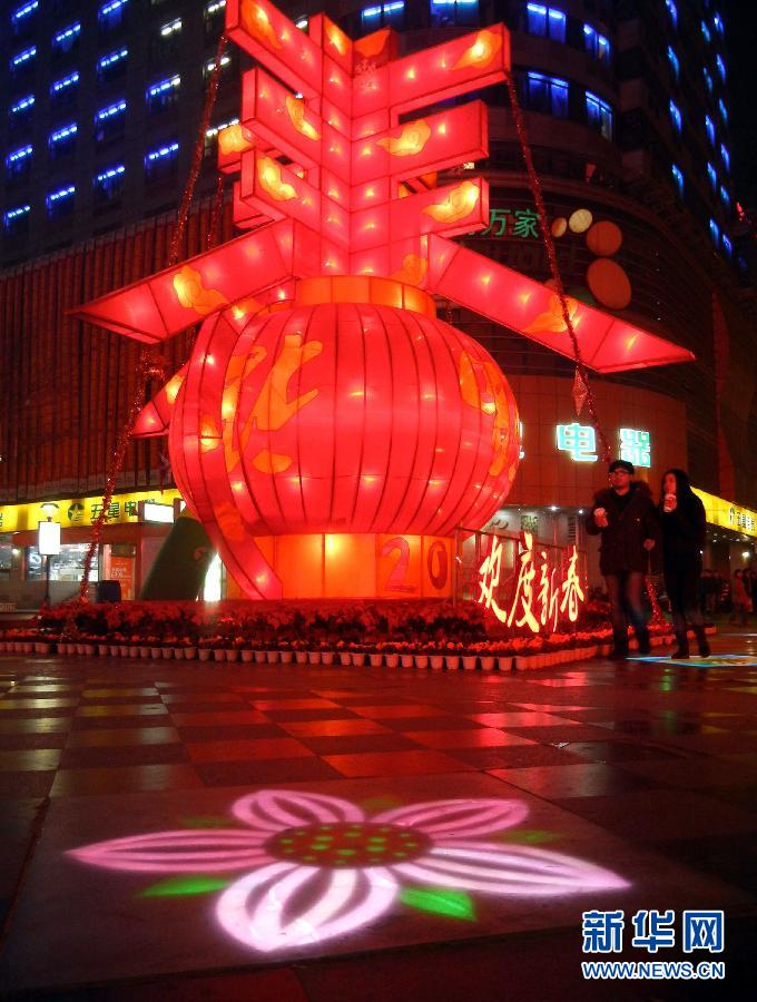 　1月30日晚，市民從蘇州市石路銀河廣場上大型“春”字彩燈景觀旁經(jīng)過。