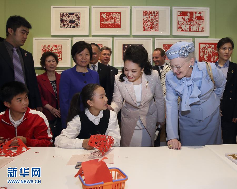 這是彭麗媛和瑪格麗特二世與根據(jù)安徒生童話中人物和情節(jié)制作剪紙的孩子交談。