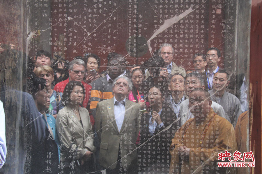 在一塊石碑前，少林寺方丈正在講解