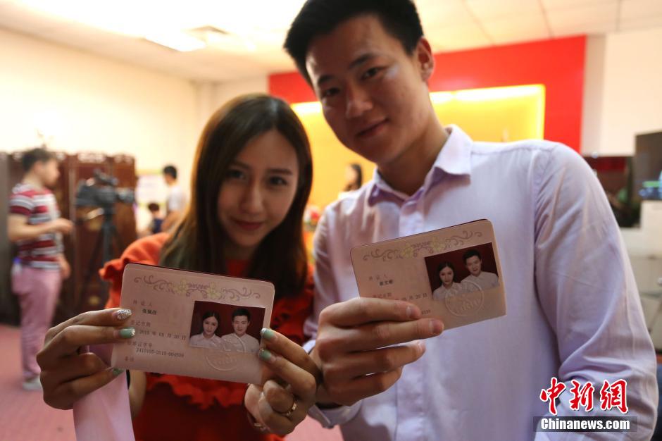 5月20日,河南鄭州,一對(duì)準(zhǔn)新人領(lǐng)完結(jié)婚證后秀自拍。