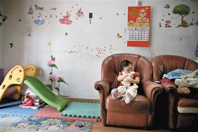 6月14日，未婚媽媽于軍的家里。女兒悅悅抱著兔子玩偶，在聽媽媽手機上的兒歌，這個4歲女孩喜歡兔子。