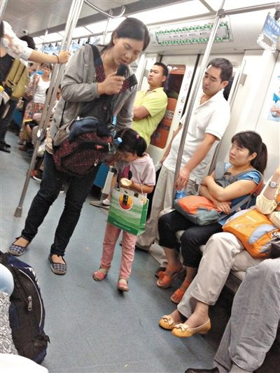 6月27日，舒馨帶一女孩在地鐵十號(hào)線行乞。她因被疑帶多個(gè)不同小孩乞討被警方搜尋。新京報(bào)記者 申志民 攝