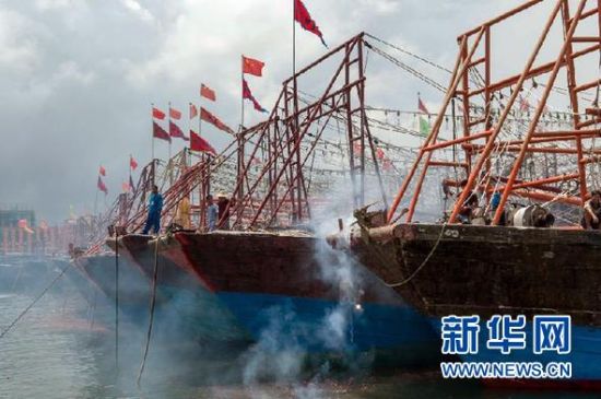2013年8月1日 南海開漁日 臨高迎新港 8月1日，海南省臨高縣漁民在船上鳴放鞭炮慶祝武蓮港開港。