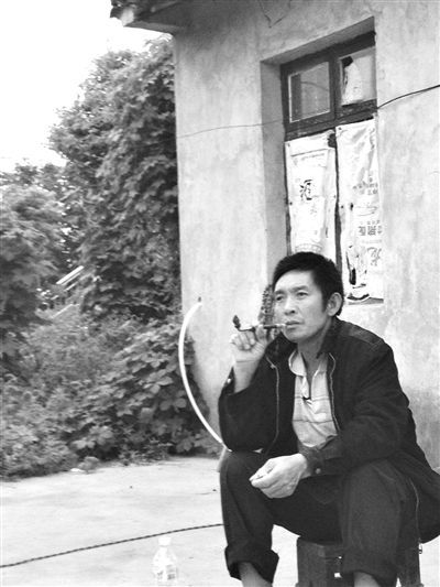 9月12日，陳文才在自己的出租屋旁抽煙。新京報(bào)記者 朱柳笛 攝