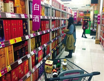 顧客在商場的高檔白酒貨架前駐足挑選。春節(jié)臨近，受“禁令”影響，以高檔白酒為代表的節(jié)日禮品市場面臨考驗。記者 王遠(yuǎn)征 攝