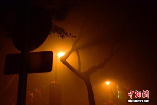 1月31日凌晨，市民行走在煙霧繚繞的南京街頭。當(dāng)天是農(nóng)歷馬年正月初一，南京有限開禁燃放煙花爆竹正逢下霧天，空氣的不流通致使煙花爆竹燃燒后產(chǎn)生的顆粒物不能及時散開，造成整座城市煙霧繚繞。據(jù)當(dāng)?shù)丨h(huán)保部門發(fā)布的信息顯示，空氣質(zhì)量屬重度污染。中新社發(fā) 泱波 攝
