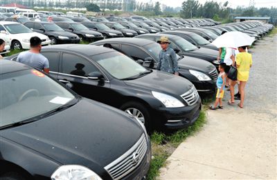 昨日，市民在山東棗莊一家拍賣公司場(chǎng)地上查看待拍賣公車。當(dāng)日，棗莊市103輛公車公開拍賣。新華社記者