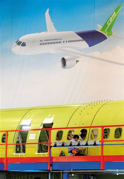 昨日，中國商飛總裝制造中心技術人員對接C919首架機的機體。新華社記者 丁汀 攝