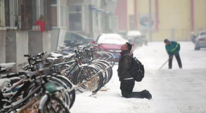 小伙子跪在樓前，一直抬頭看著樓上。 孫立國(guó)/攝