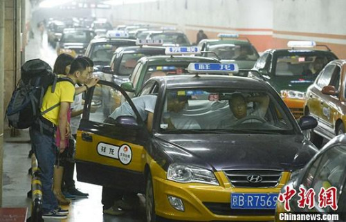 市民在北京西客站出租車候車點準備乘車。中新社發(fā) 侯宇 攝