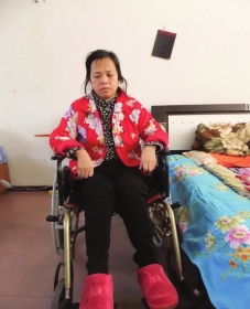 陳慶霞坐在輪椅上。她現(xiàn)在下身癱瘓，疾病纏身，生活不能自理。