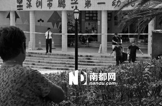 →7月19日，鵬興花園第一幼兒園門前，民警在現(xiàn)場(chǎng)進(jìn)行完勘查取證后，園長和保安的尸體被運(yùn)走。南都記者 徐文閣 攝