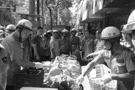 7月11日，瀏陽市北正中路，執(zhí)法人員暫扣張海的水果。這是瀏陽市城管局拍攝的執(zhí)法現(xiàn)場圖。