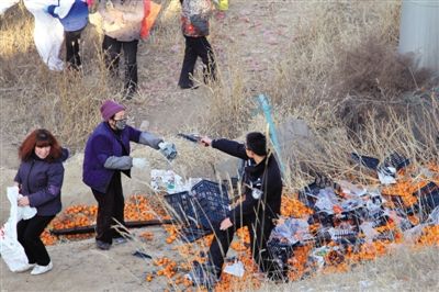 1月4日，連霍高速蘭州市榆中縣和平鎮(zhèn)段，一名警察舉著槍驅(qū)散哄搶橘子的村民。圖/CFP