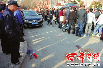 車禍現(xiàn)場的血跡被人用土覆蓋，旁邊則放著紅領(lǐng)巾、一雙童鞋和一頂帽子 本報(bào)記者 趙彬 攝