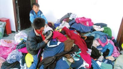 學生在幫忙整理收到的捐贈衣服。得石中心校供圖