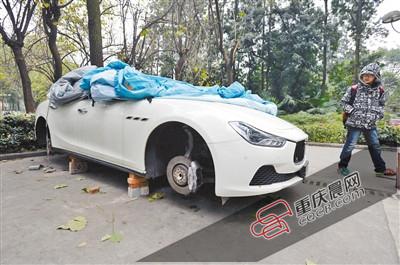 昨日，停放在重慶大學(xué)B區(qū)的一輛瑪莎拉蒂豪車(chē)被架在幾塊磚頭上，車(chē)輪不翼而飛。 重慶晨報(bào)記者 胡杰 攝