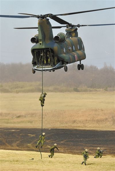 “登島” 1月13日，位于東京的習(xí)志野市，日本自衛(wèi)隊隊員在新年軍演中演練直升機(jī)登島行動。