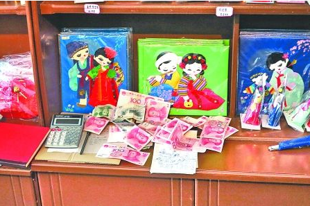 　　2012年6月21日，在朝鮮羅先特別市的一家商店里，柜臺上散落著一些人民幣。在朝鮮，人民幣比本國