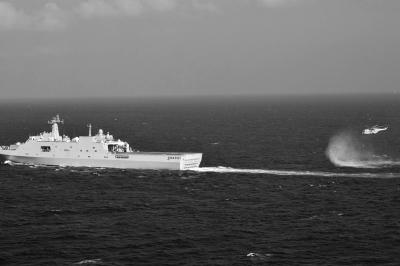 11日，抵達(dá)馬航飛機(jī)失聯(lián)海區(qū)的海軍井岡山艦與艦載直升機(jī)協(xié)同展開立體搜救行動(dòng)。新華社發(fā)
