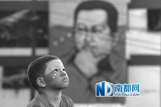 3月5日，一名委內(nèi)瑞拉兒童仰望天空，他身后是查韋斯的陵墓。