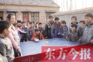 坐著輪椅的小宗成和同學(xué)們一塊打乒乓球，這是他感到最快樂的事
