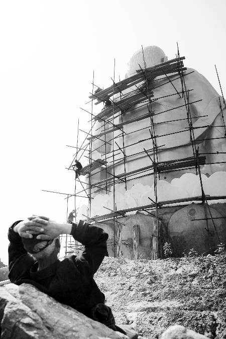 今年4月26日，工作人員將帆布蓋在“佛像”頭像上