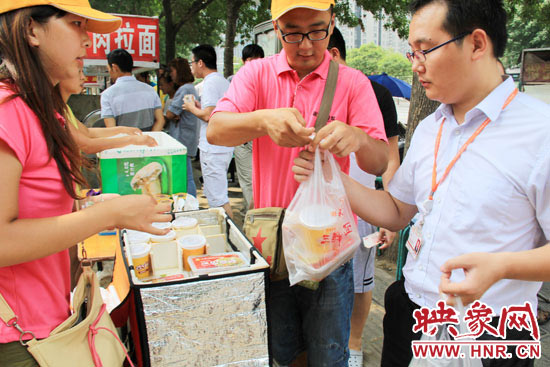圖為徐貴雨和一名勤工助學(xué)的學(xué)生在街頭義賣快餐。