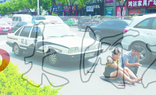 事故發(fā)生后，警車司機（右）下車查看傷者并撥打120，倆“領導”穩(wěn)坐車內引發(fā)圍觀者不滿。