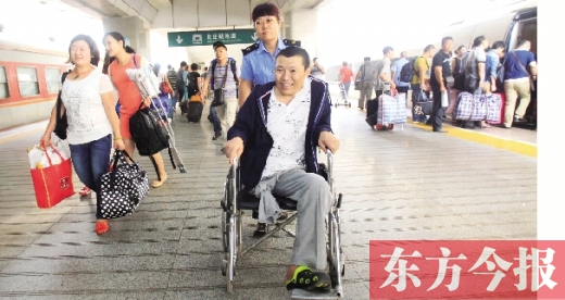 李剛手術(shù)后歸來，在車站工作人員幫助下走出鄭州火車站站臺  東方今報首席記者 張曉冬 攝