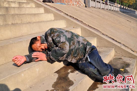 這名男子的衣服以及褲子全濕透了，水從衣褲里流出來，嘴里散發(fā)著濃烈的酒氣。