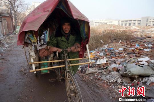 圖為老人走出窩棚，推著三輪車準備出去撿拾廢品。周小云 攝