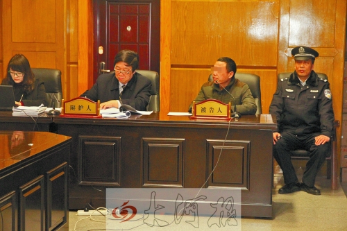庭審現(xiàn)場，被告人坐在律師身旁為自己辯護(hù)。