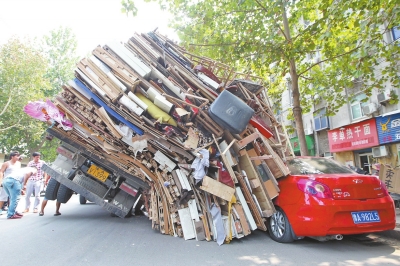 紅色小轎車(chē)被砸，卡在路邊動(dòng)彈不得。