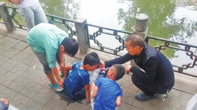 男孩被救出后，圍觀群眾幫他控水換衣服。
