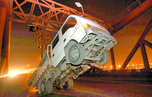 　車上升降機的工作臺被卡，車身前部高高翹起。
