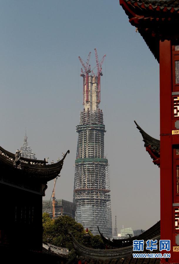 在上海豫園遠眺在建的國內(nèi)第一高樓“上海中心”（4月11日攝）。