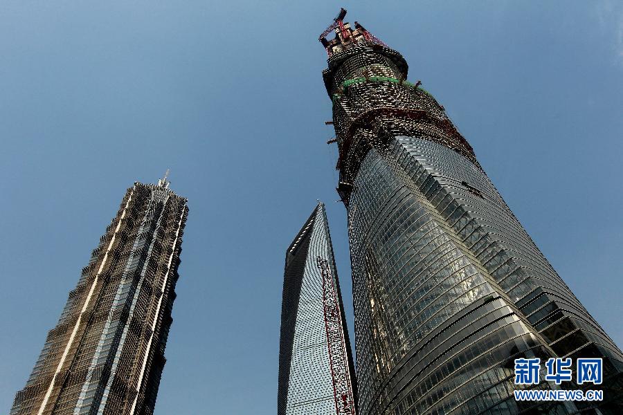 4月11日，正在建設(shè)中的“上海中心”（右）的高度已超過金茂大廈（左）和上海環(huán)球金融中心（中）。